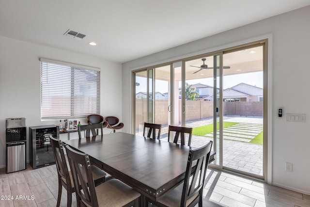 dining space with wine cooler, light hardwood / wood-style floors, and a wealth of natural light