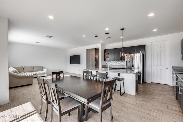 dining space with light wood-type flooring and sink