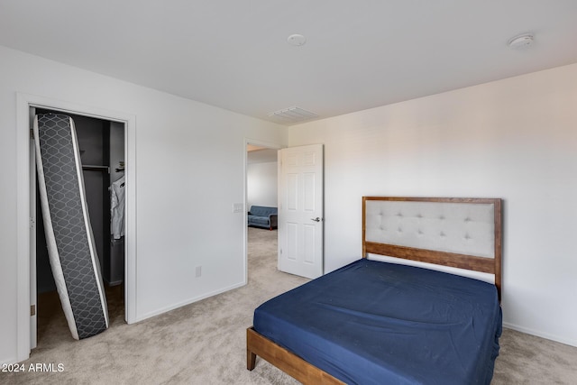 carpeted bedroom with a walk in closet and a closet