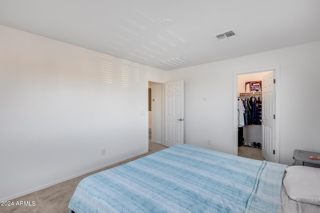 carpeted bedroom with a spacious closet and a closet