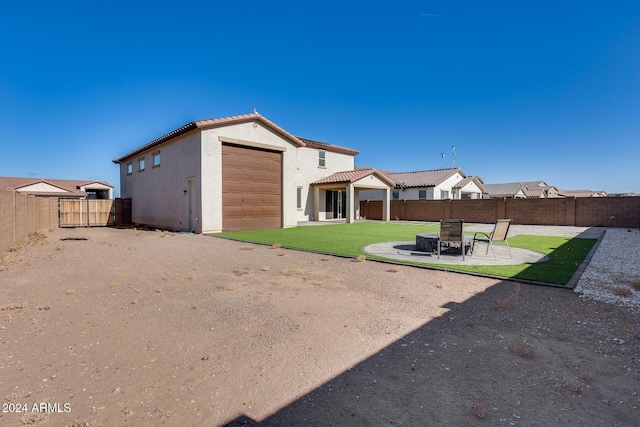 rear view of house featuring a yard, an outbuilding, a patio, and a garage