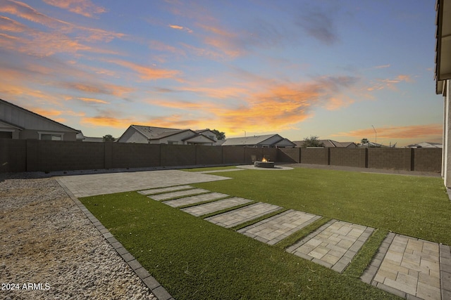 yard at dusk with a patio and an outdoor fire pit