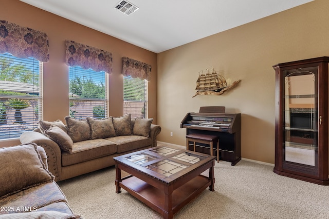 living area with light colored carpet, baseboards, visible vents, and plenty of natural light