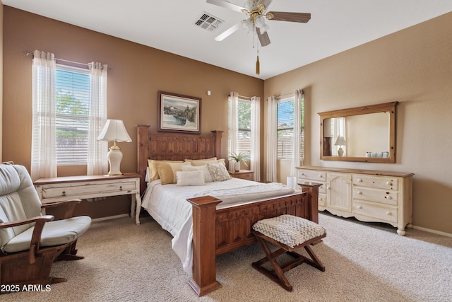 carpeted bedroom with ceiling fan, visible vents, multiple windows, and baseboards
