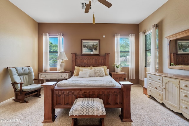 bedroom with multiple windows, light carpet, and a ceiling fan