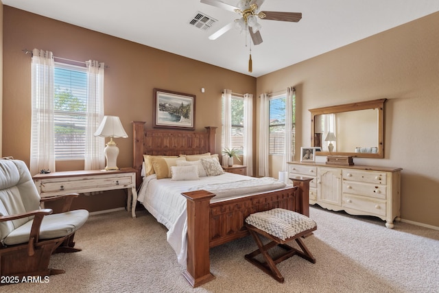 carpeted bedroom featuring a ceiling fan, baseboards, visible vents, and multiple windows