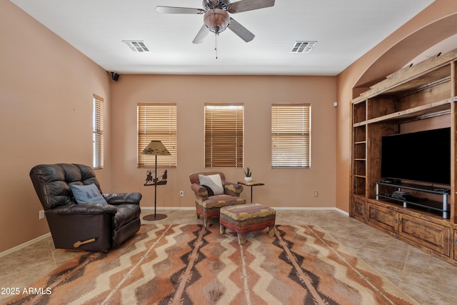 living area featuring a ceiling fan, baseboards, and visible vents