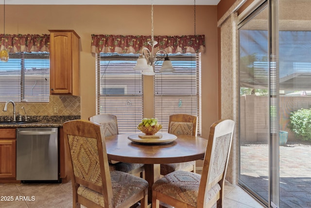 dining area with light tile patterned flooring, an inviting chandelier, and a healthy amount of sunlight