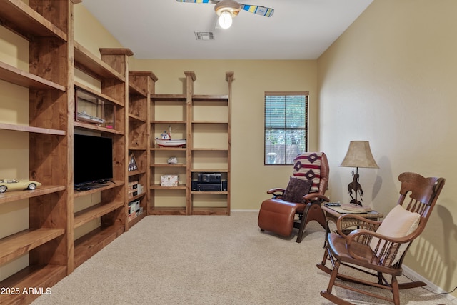 sitting room with carpet floors, baseboards, a ceiling fan, and visible vents
