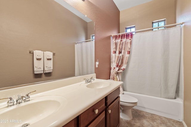 bathroom with double vanity, a sink, shower / bath combo, and toilet