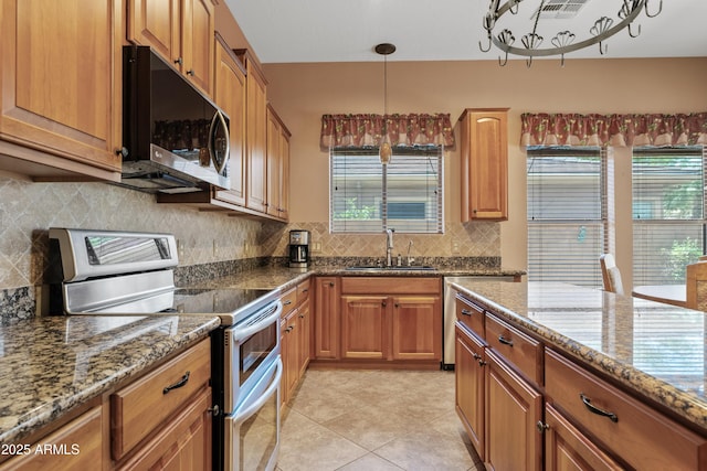 kitchen featuring a sink, decorative backsplash, stone counters, and double oven range