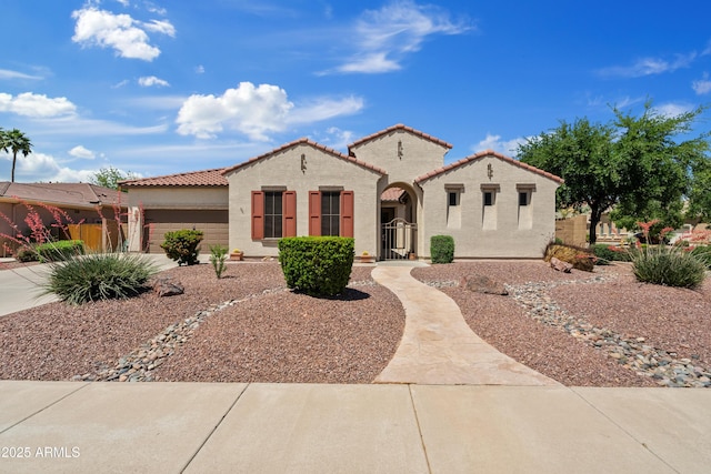 mediterranean / spanish house featuring a tiled roof, a garage, fence, concrete driveway, and stucco siding