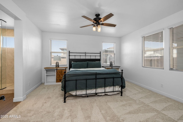 bedroom featuring multiple windows, baseboards, and light carpet