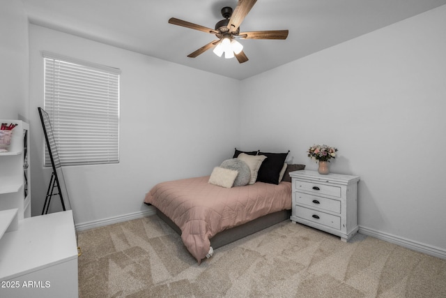 bedroom with a ceiling fan, baseboards, and light carpet