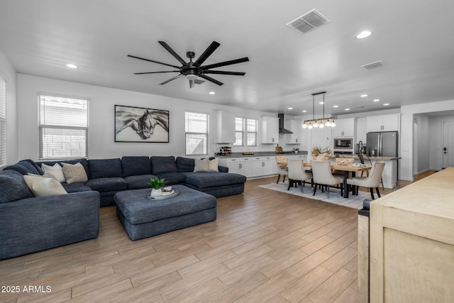 living room featuring a ceiling fan, recessed lighting, visible vents, and light wood-type flooring