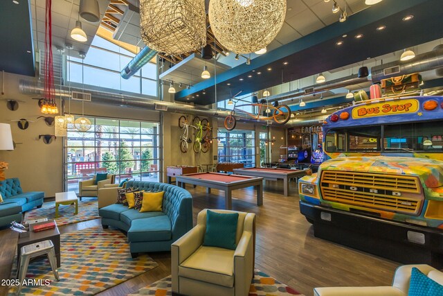 recreation room featuring wood finished floors, visible vents, an inviting chandelier, pool table, and a towering ceiling