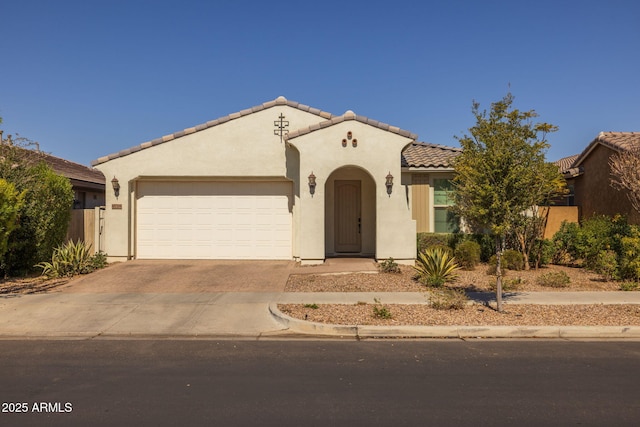 mediterranean / spanish-style house featuring stucco siding, an attached garage, a tile roof, and decorative driveway