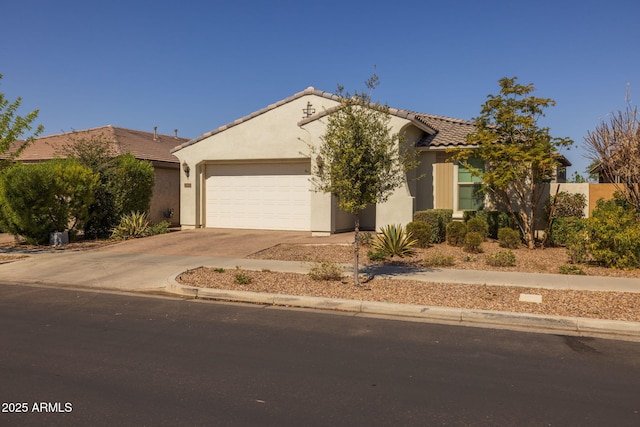 view of front of house with stucco siding, concrete driveway, an attached garage, and a tiled roof