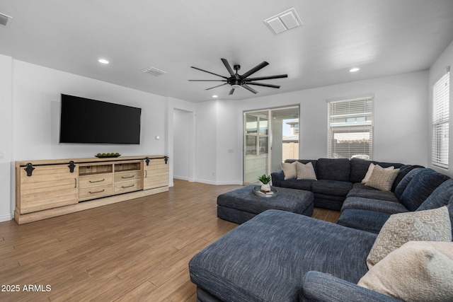 living room with recessed lighting, visible vents, plenty of natural light, and wood finished floors