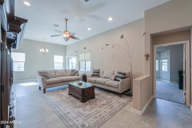 living room with ceiling fan with notable chandelier and a healthy amount of sunlight