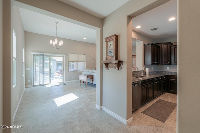 kitchen featuring dark brown cabinetry, sink, stainless steel dishwasher, dark stone counters, and a chandelier