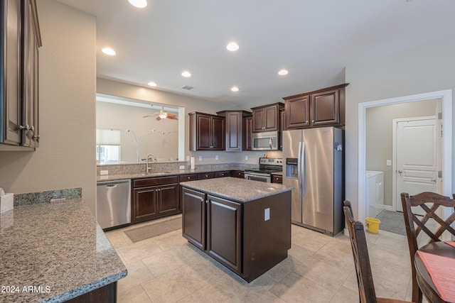 kitchen featuring dark brown cabinets, a center island, stainless steel appliances, and sink