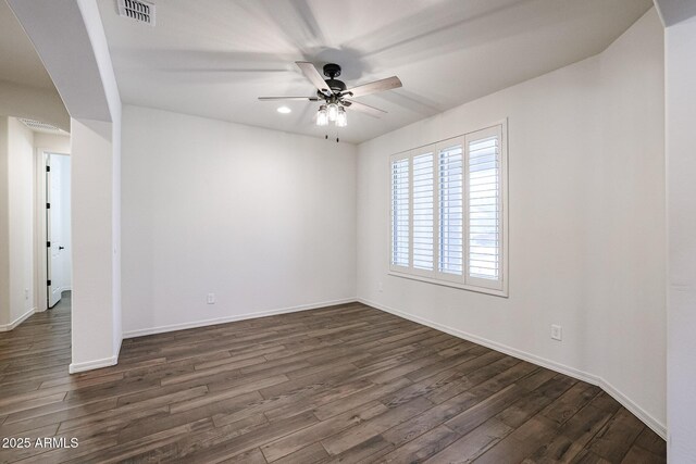 unfurnished living room featuring ceiling fan, dark hardwood / wood-style floors, and a barn door