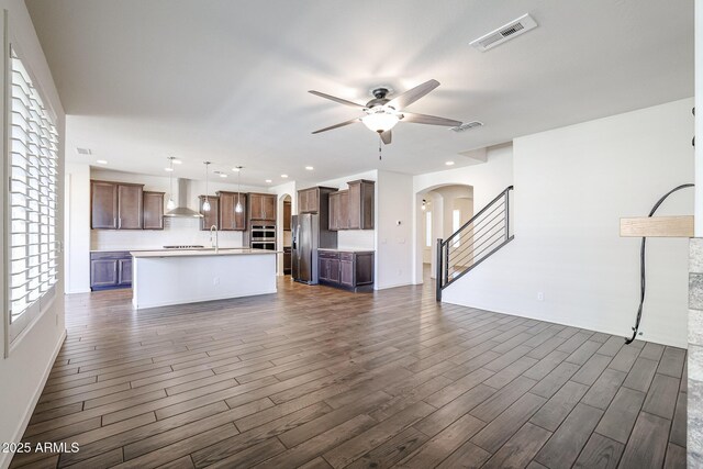 living room with ceiling fan, dark hardwood / wood-style floors, and a barn door