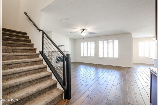 bedroom featuring dark colored carpet, ceiling fan, and a barn door