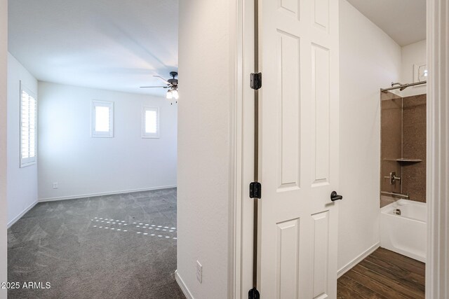 unfurnished living room featuring ceiling fan and dark wood-type flooring