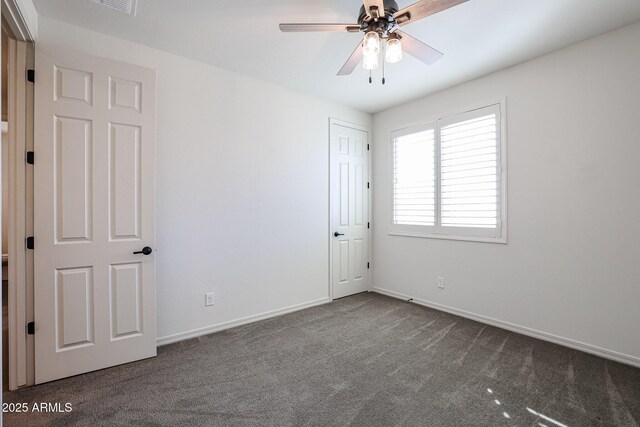 unfurnished bedroom featuring dark carpet and ceiling fan