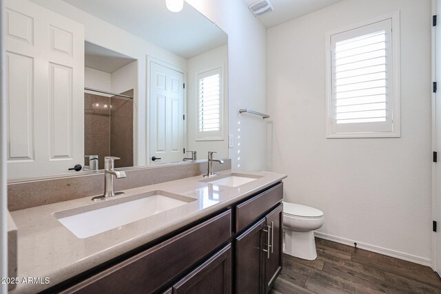 bathroom with walk in shower, vanity, toilet, and hardwood / wood-style flooring