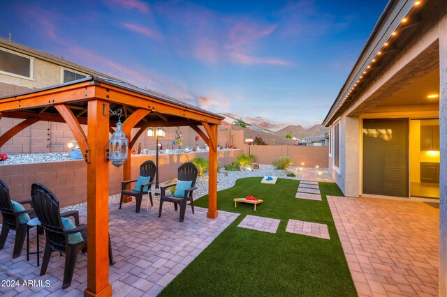 yard at dusk with a patio and a gazebo