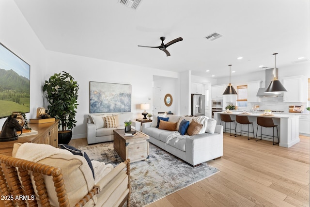 living room featuring ceiling fan and light wood-type flooring