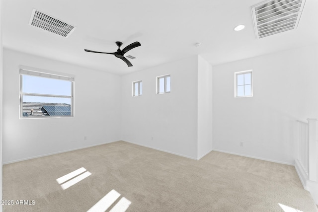 spare room featuring light colored carpet and ceiling fan