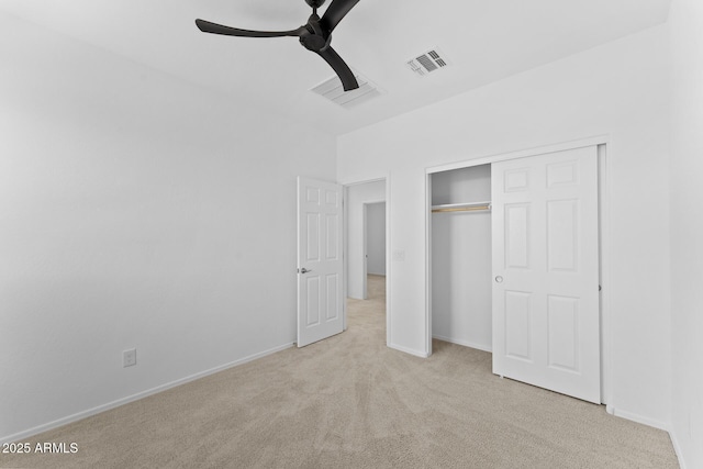 unfurnished bedroom with light colored carpet, ceiling fan, and a closet