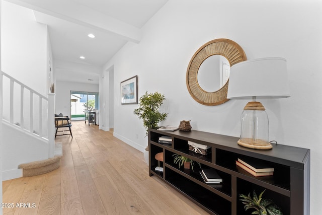 hall featuring beamed ceiling and light wood-type flooring