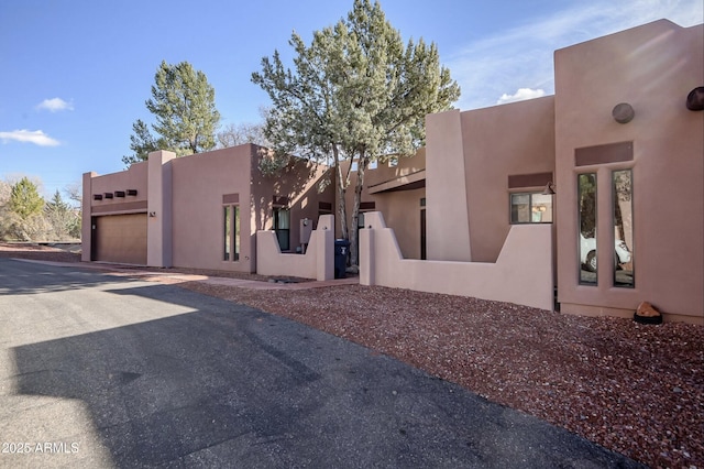 33 Monterey Cir, Sedona, AZ 86351 - view of front facade featuring an attached garage, stucco siding, and asphalt driveway