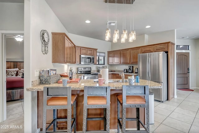 33 Monterey Cir, Sedona, AZ 86351 - kitchen with appliances with stainless steel finishes, light stone counters, light tile patterned floors, a peninsula, and pendant lighting