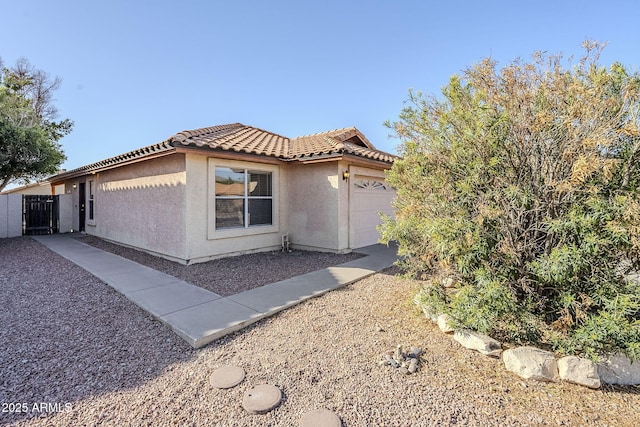 view of property exterior featuring a tiled roof, an attached garage, and stucco siding