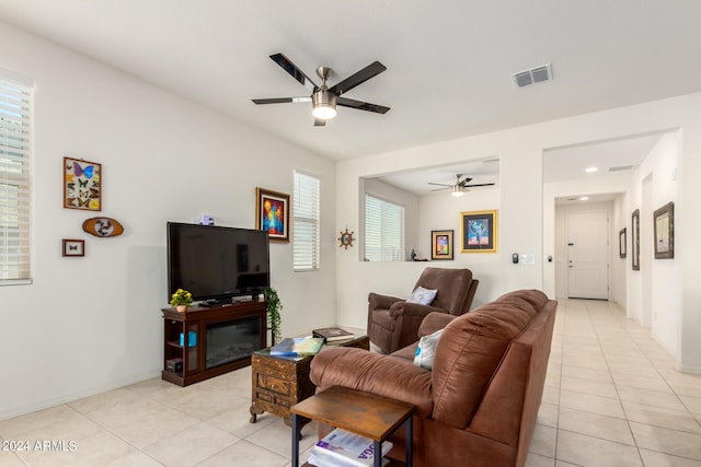 living room featuring ceiling fan, a healthy amount of sunlight, and light tile floors