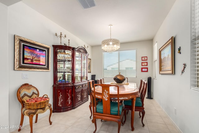 dining room featuring light tile flooring and a chandelier