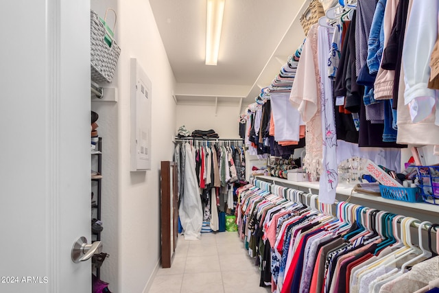 walk in closet with light tile flooring