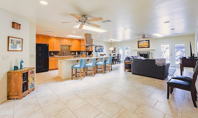 kitchen featuring freestanding refrigerator, light countertops, island exhaust hood, and ceiling fan