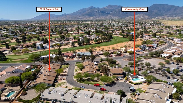 birds eye view of property with view of golf course, a mountain view, and a residential view