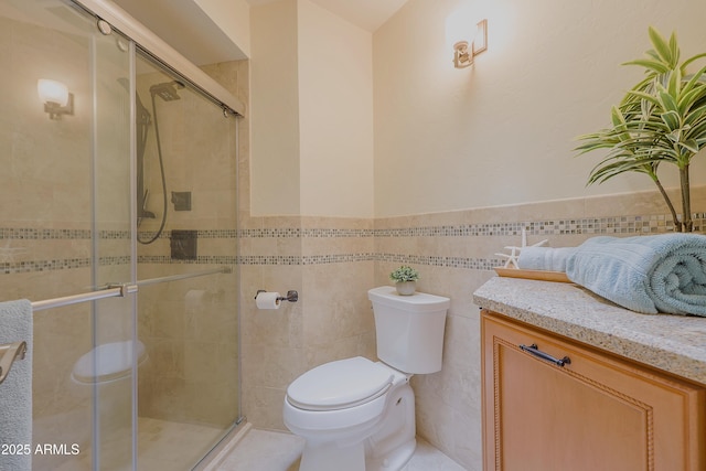 full bath with tile walls, toilet, a shower stall, and a wainscoted wall