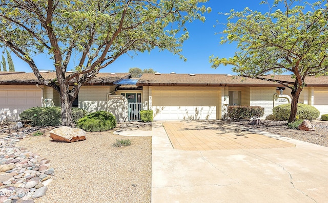 ranch-style house featuring concrete driveway, brick siding, and a garage
