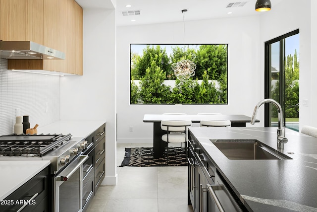 4002 N 33rd Pl, Phoenix, AZ 85018 - kitchen with appliances with stainless steel finishes, a sink, under cabinet range hood, pendant lighting, and decorative backsplash