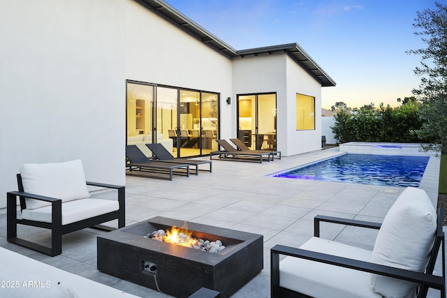 4002 N 33rd Pl, Phoenix, AZ 85018 - back of house at dusk featuring a patio area, an outdoor living space with a fire pit, an outdoor pool, and stucco siding