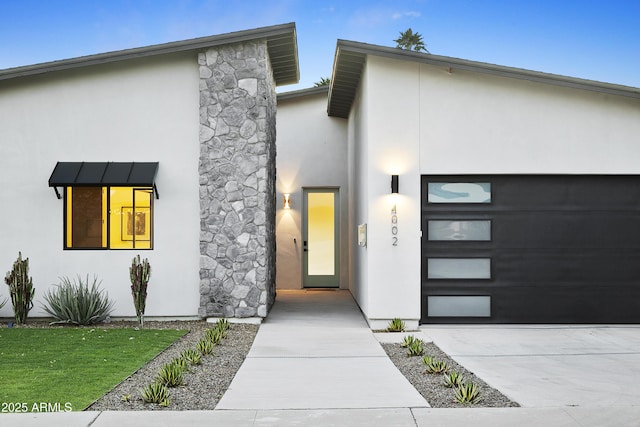 4002 N 33rd Pl, Phoenix, AZ 85018 - contemporary home featuring stucco siding, an attached garage, concrete driveway, and stone siding